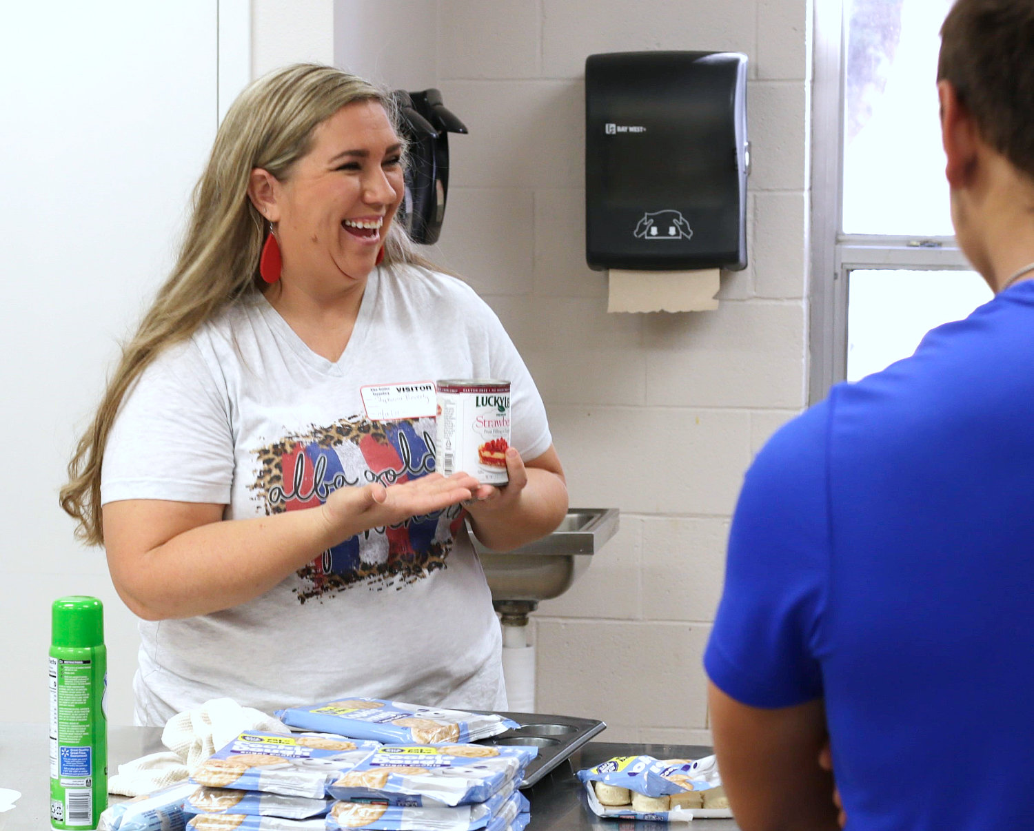 Stephanie Beverly shares a laugh with seniors while discussing meal preparation in the high school kitchen.